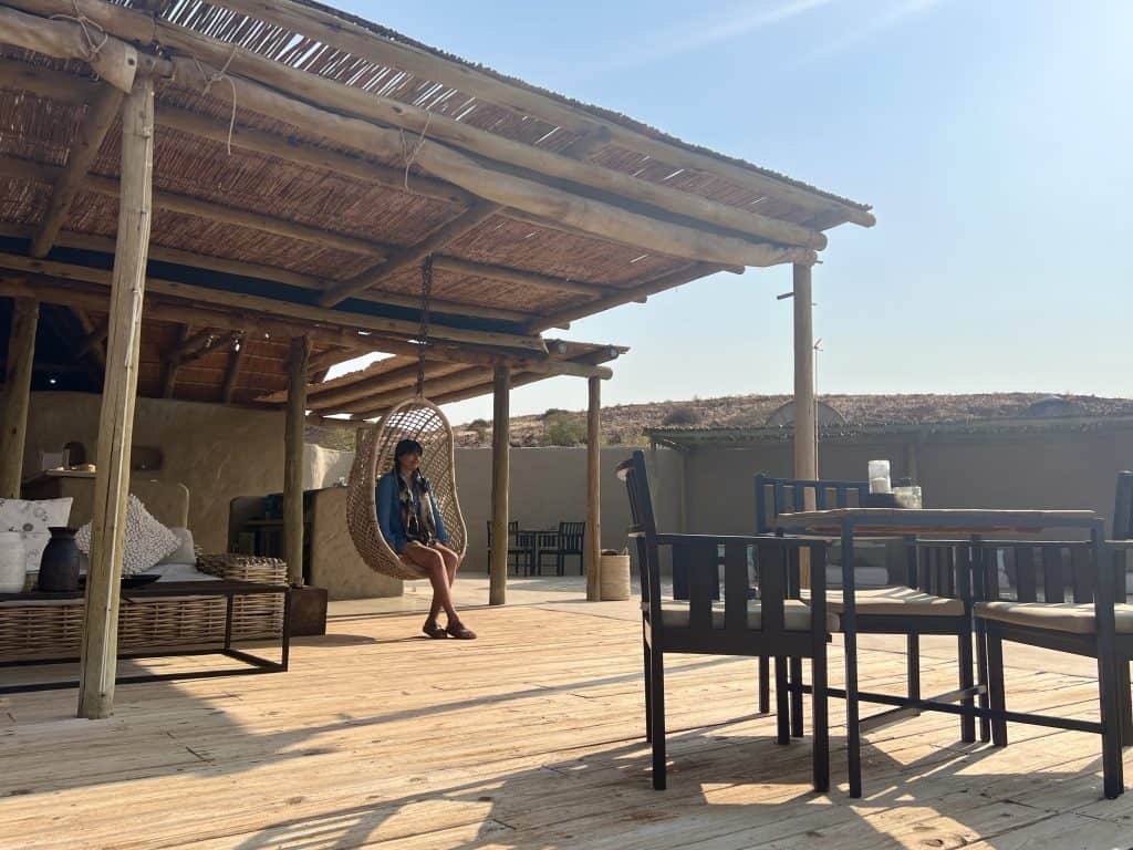 Eco-friendly Lodges in Namibia: Damaraland Camp Dining area with Bejal in chair