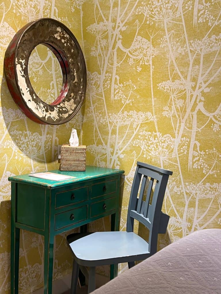 The Falstaff cosy room chair and mirror with mustard walls featuring white plant stem print.