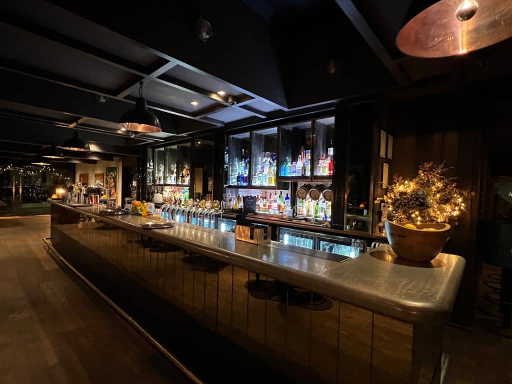 The Falstaff, Canterbury bar with drinks during the evening. The drinks have been lit up with a back lighter against a dark bar area.