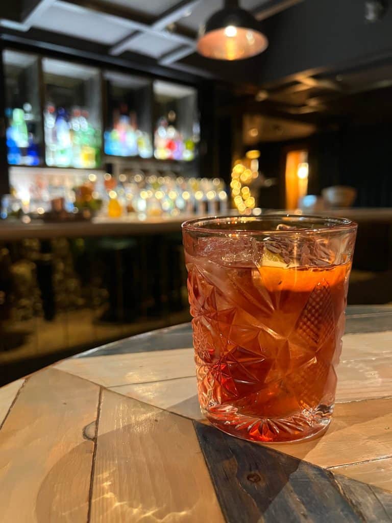A chocolate orange negroni at the hotel bar with drinks in the background at The Falstaff, Canterbury