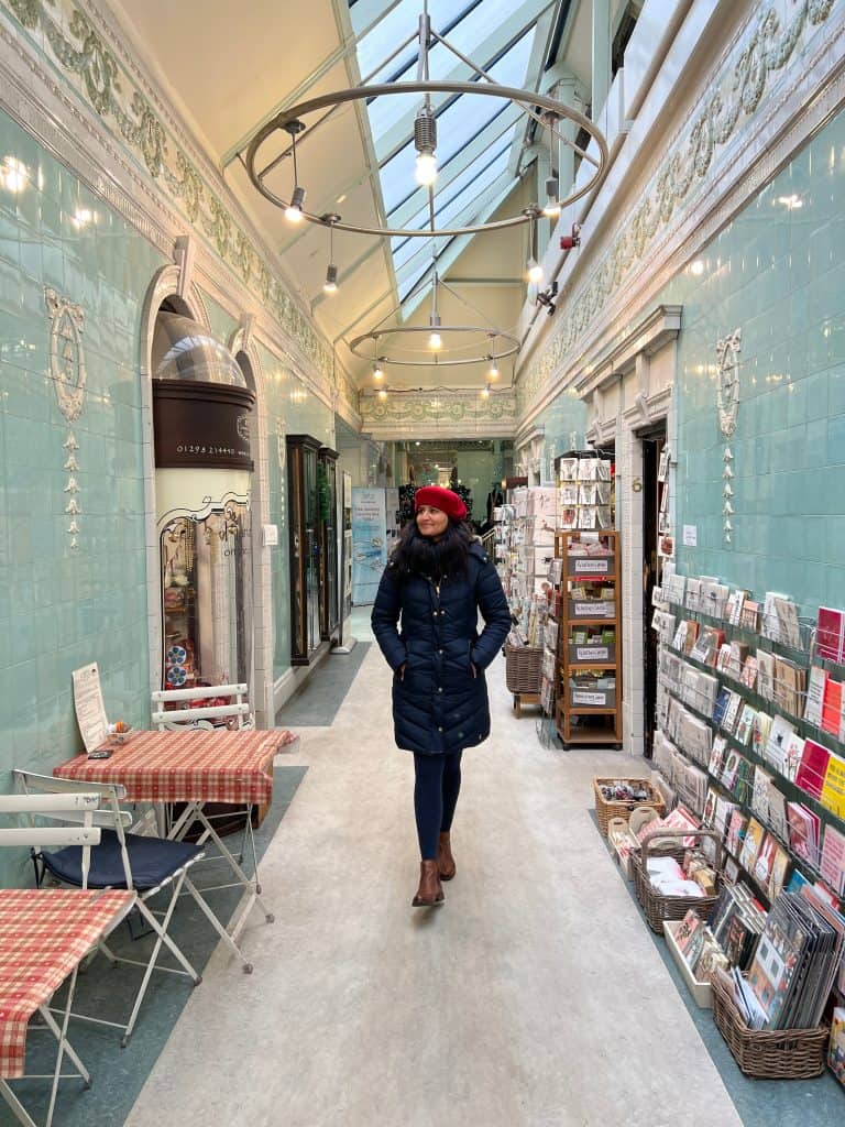 Bejal walking down Cavendish Arcade interior shop lined corridor