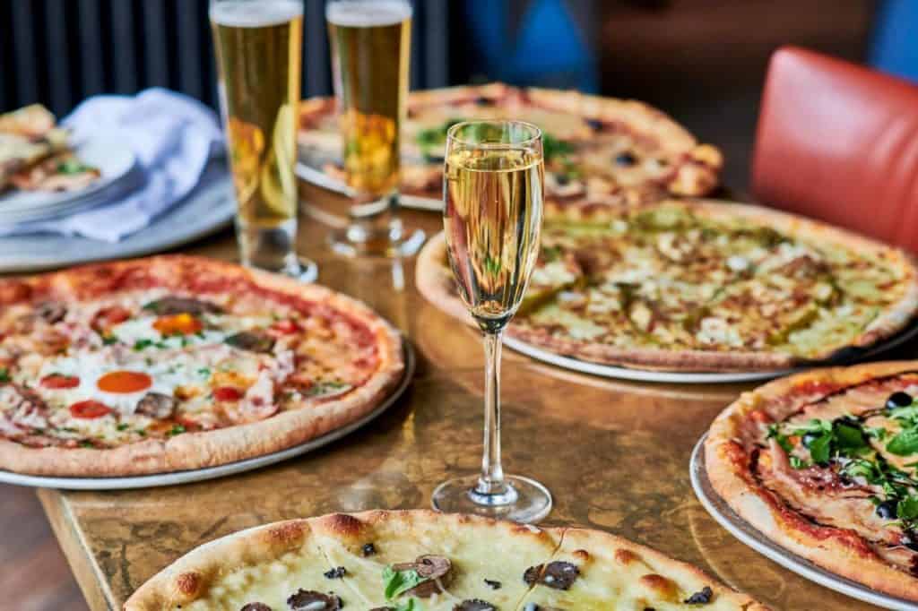 Pizza and prosecco at The Falstaff. Canterbury with various pizzas on a wooden table 