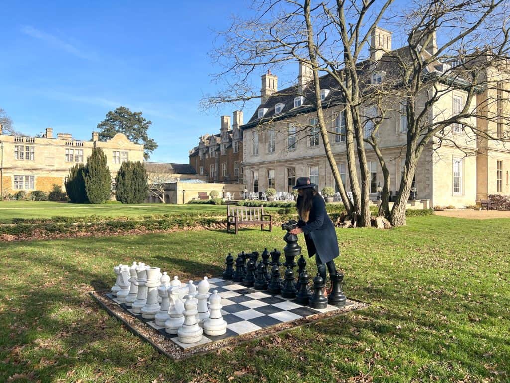 Bejal playing lawn chess with Stapleford Park Hotel in background