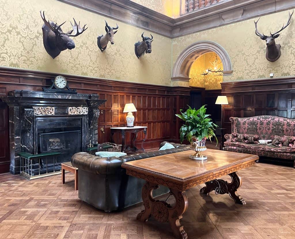 The reception room with fireplace, taxidermy and Chesterfield sofa