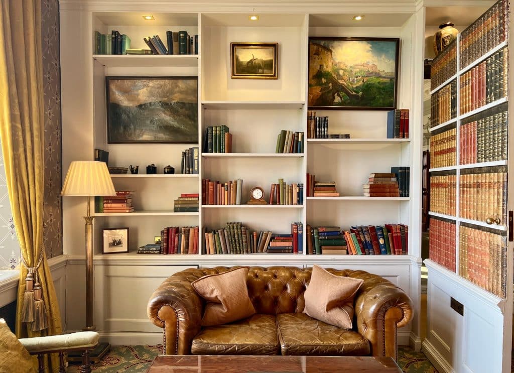 The Library Bar with light brown chesterfield sofa and bookcase
