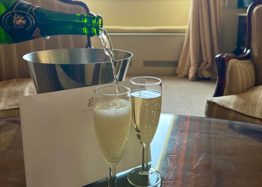 Pouring champagne into Champagne flutes in the Baker Suite