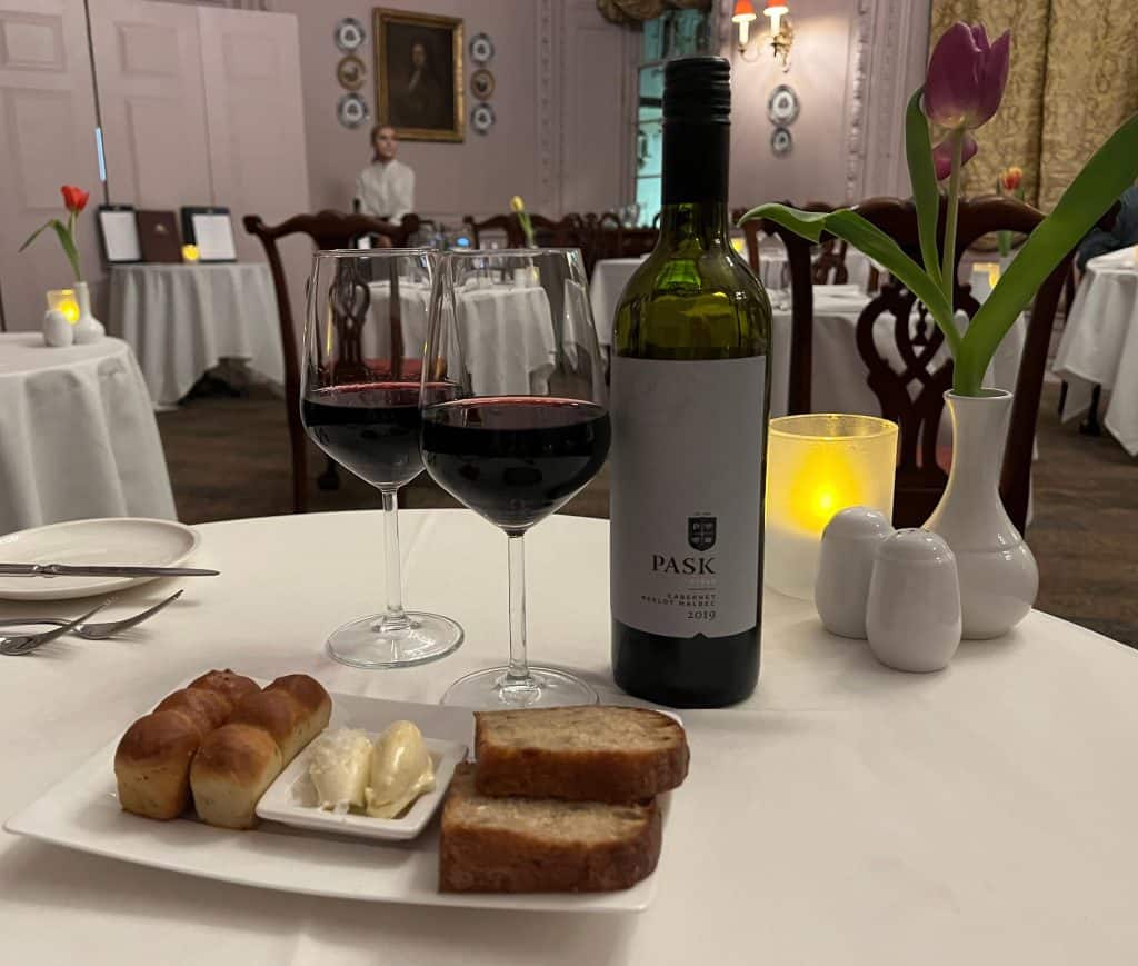 Fresh bread and butter with a bottle of red wine in the background at the restaurant for dinner