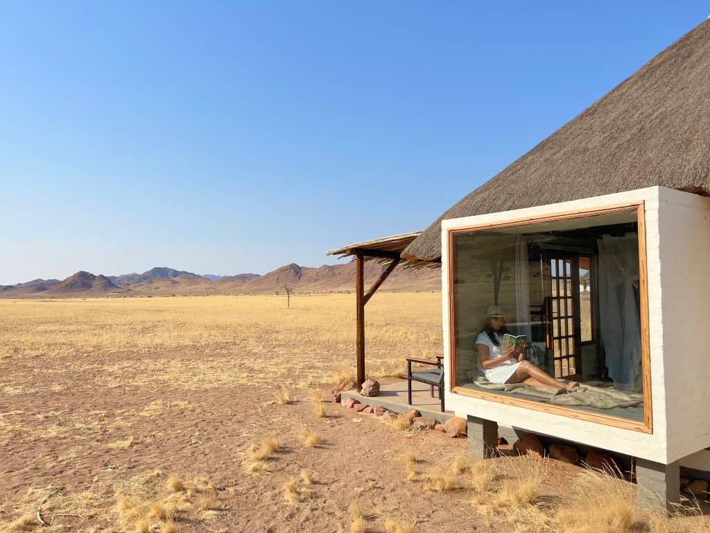 Bejal in window of desert Homestead thatched hut