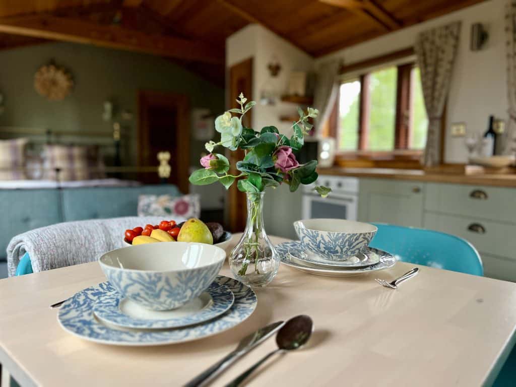 Mallory Meadows Boutique Cabin Stay: Table set up in Squirrel cabin with kitchenette in background