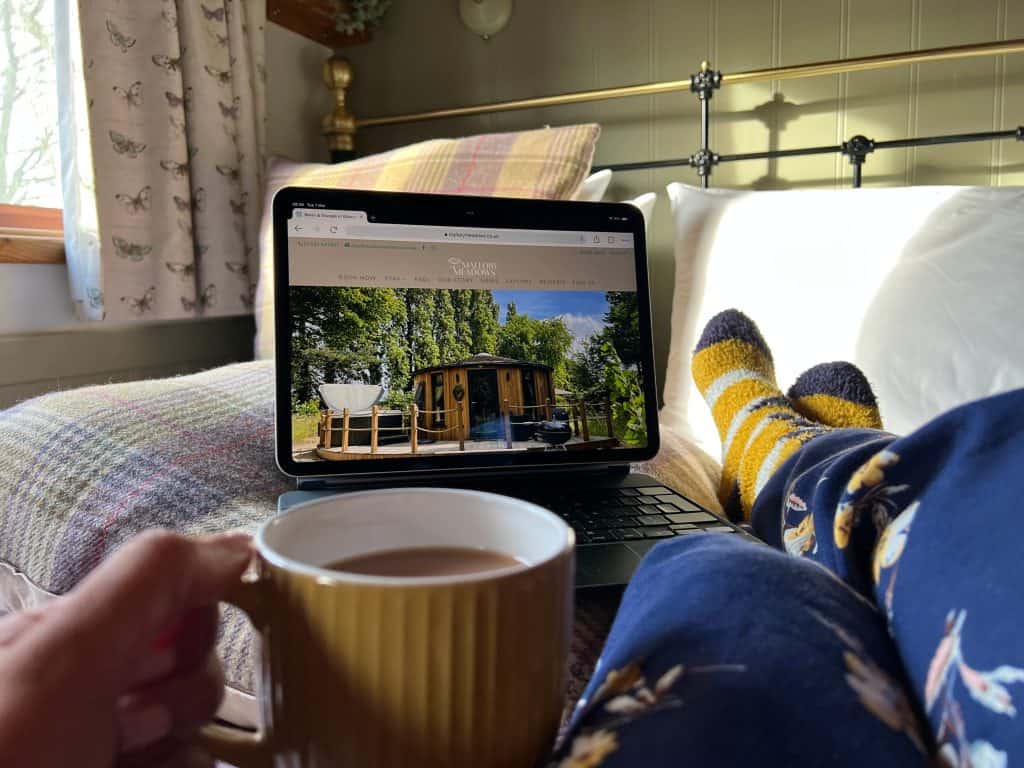 Mallory Meadows Boutique Cabin Stay: Bejal looking at Mallory Meadows website with tea and pyjamas in bed