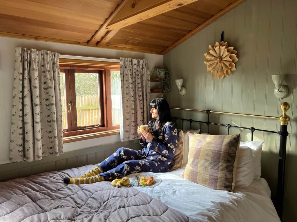 Mallory Meadows Boutique Cabin Stay: Bejal sitting on bed having breakfast