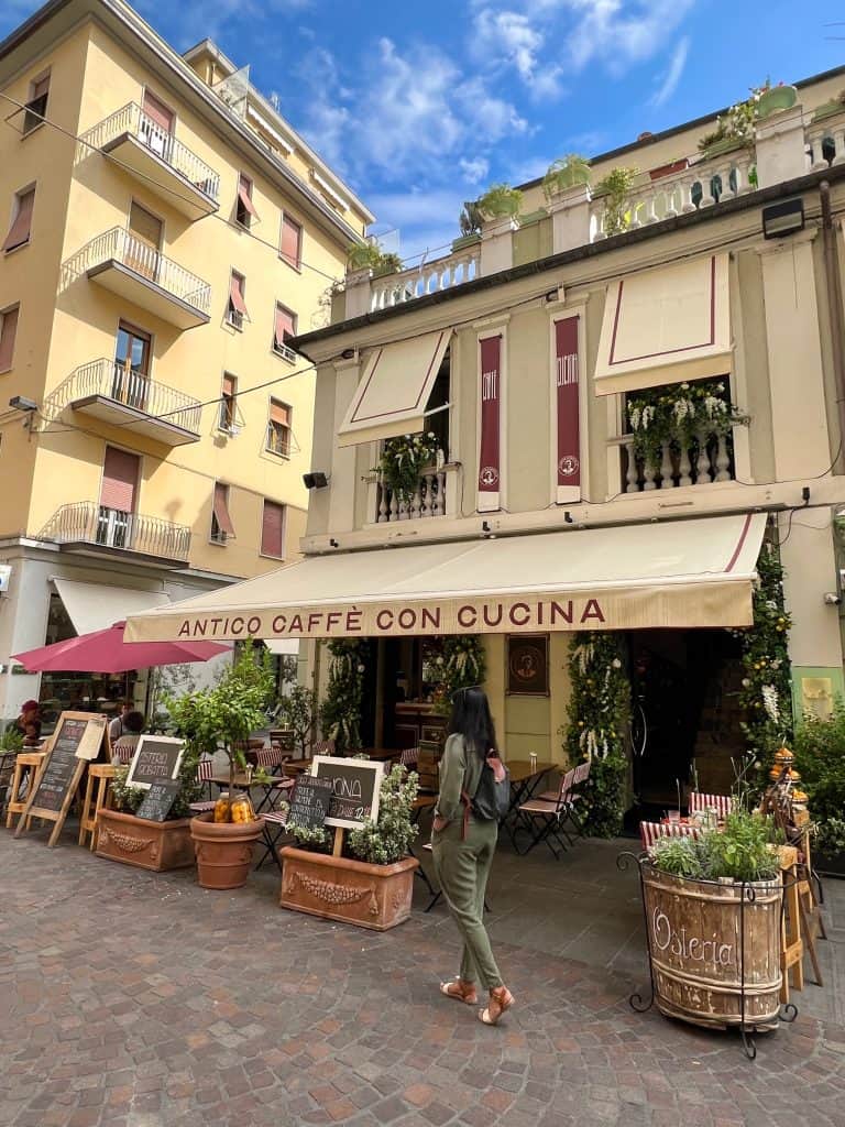 Bejal walking past cafe in La Spezia