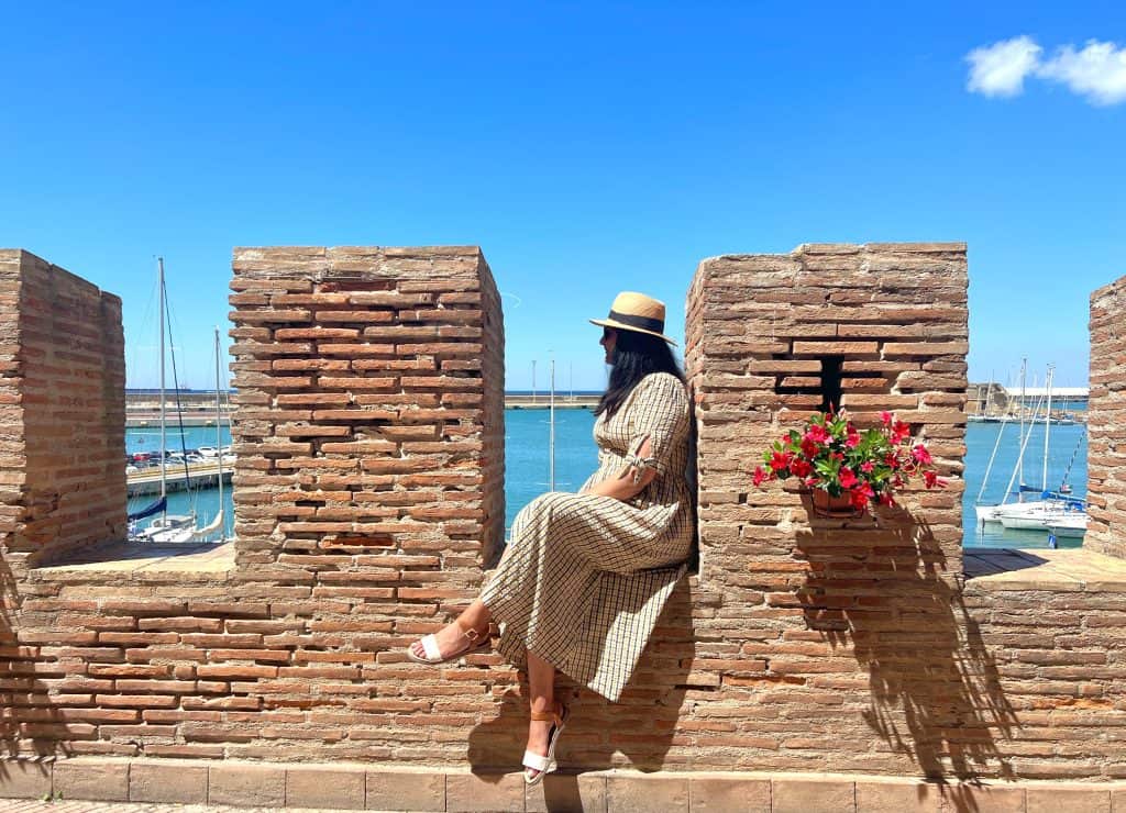 One day in Civitavecchia: Bejal sitting on defence wall with views of yachts in the background
