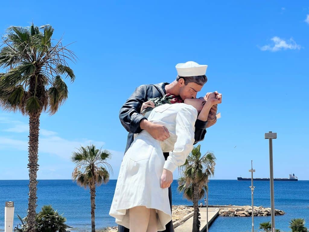 One day in Civitavecchia: Sailor kissing nurse sculptor on waterfront with sea in the background