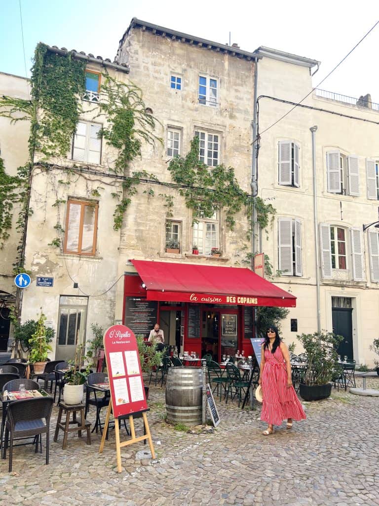 Bejal walking in front of red fascia restaurant