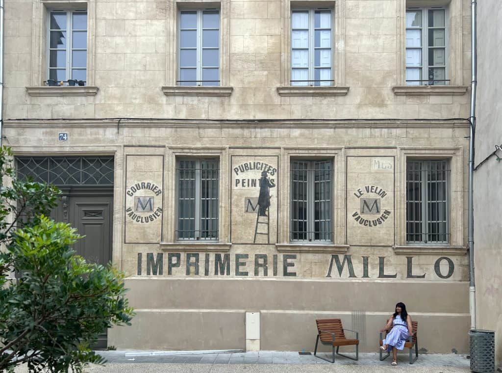 Bejal sitting in front of Avignon preserved building facade