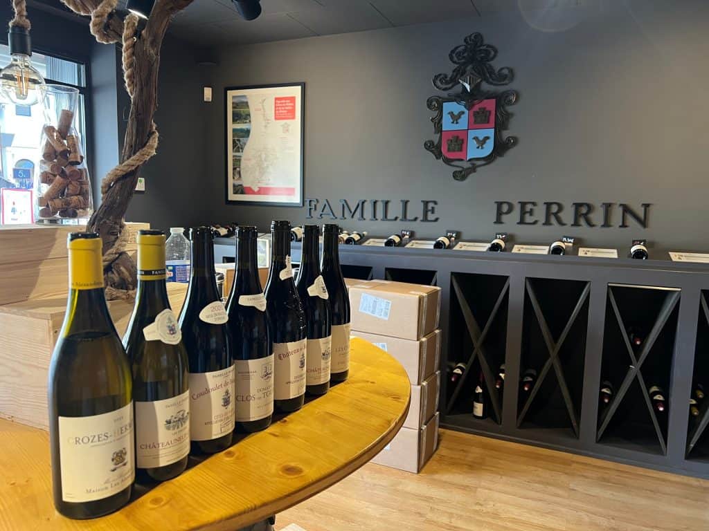 Wineries in Châteauneuf-du-Pape:bottles of wines to taste at Domaine de Beaucastel cellar Perrin family signage