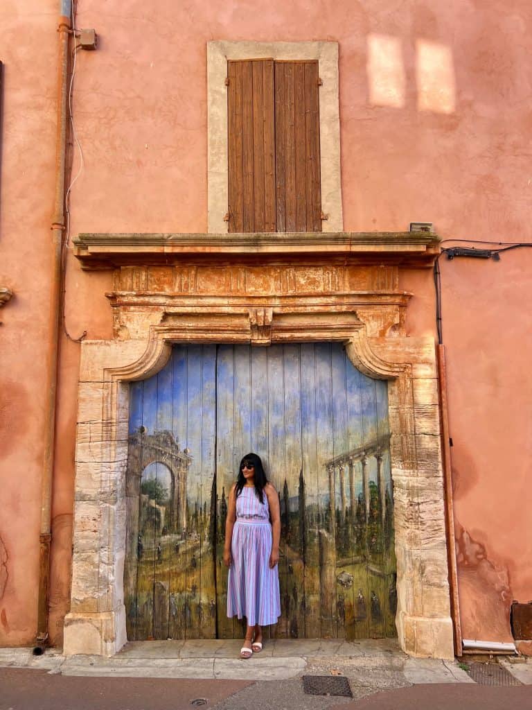 Beautiful villages to visit in Provence: Bejal standing in front of mural in Roussillon