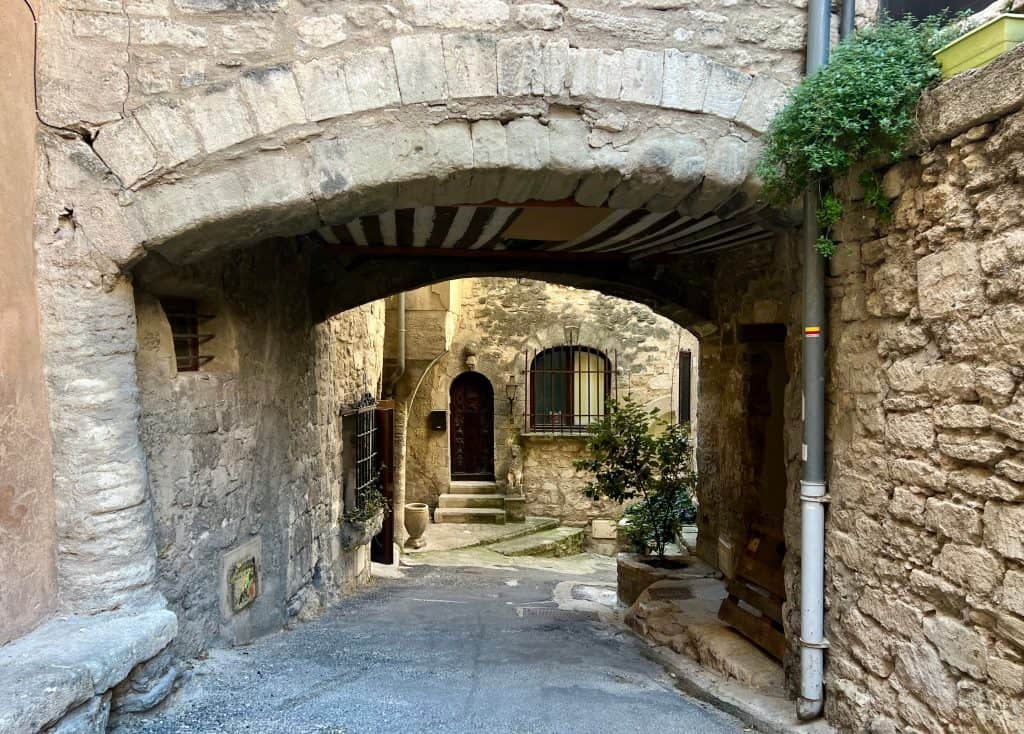 Stone archway with house in the distance in Bonnieux