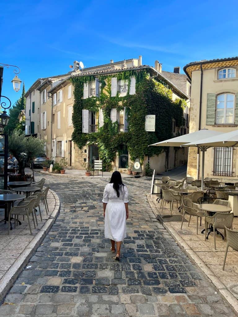 Beautiful villages to visit in Provence: Bejal walking down Lourmarin street with cafes on either side