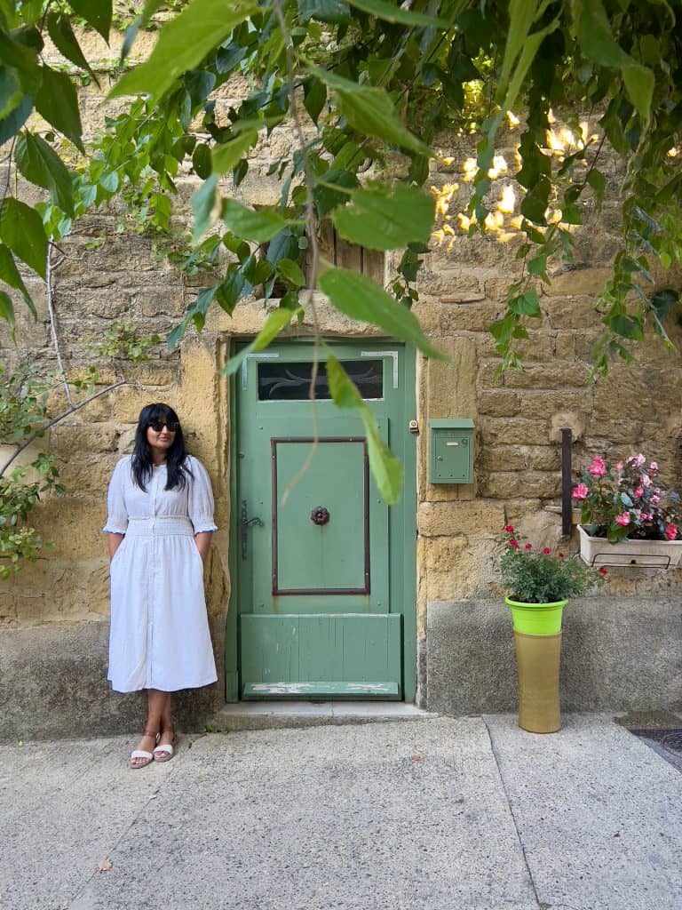 Beautiful villages to visit in Provence: Bejal standing outside green door in Lourmarin