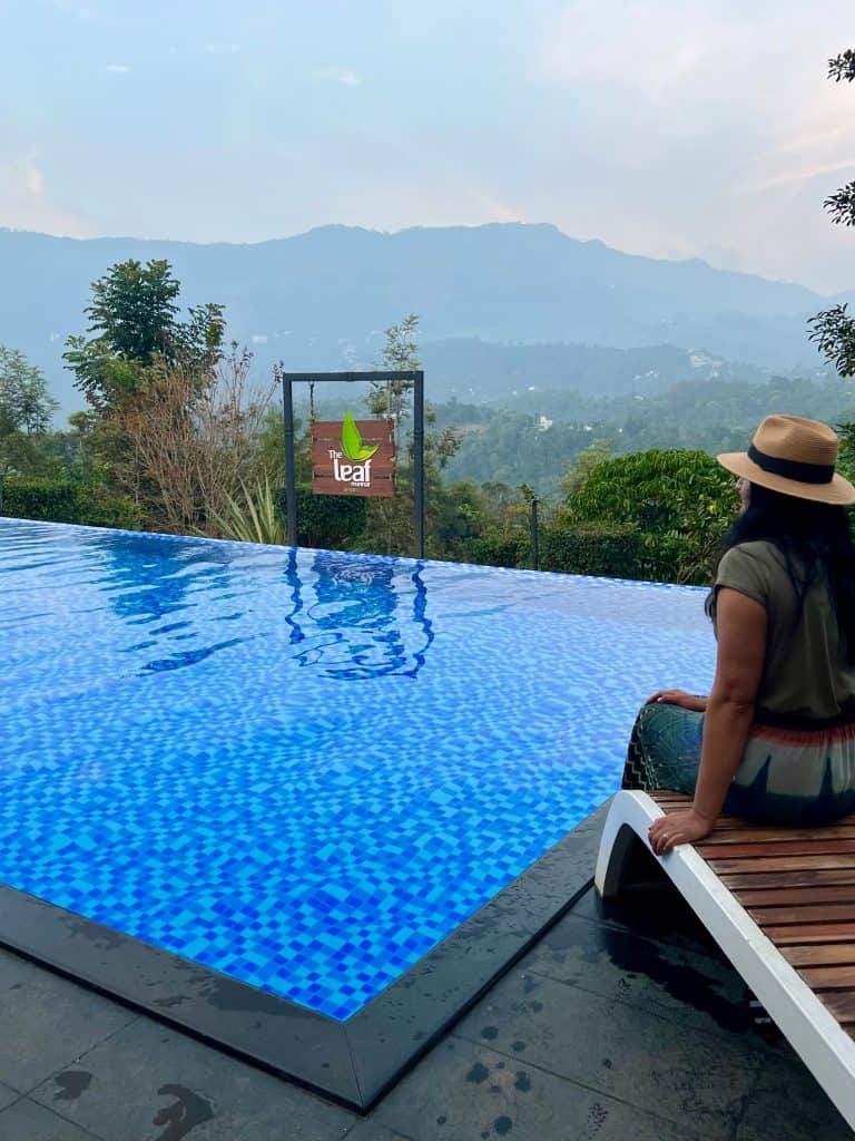 Bejal sitting at side of infinity pool at The Leaf Resort, Munnar