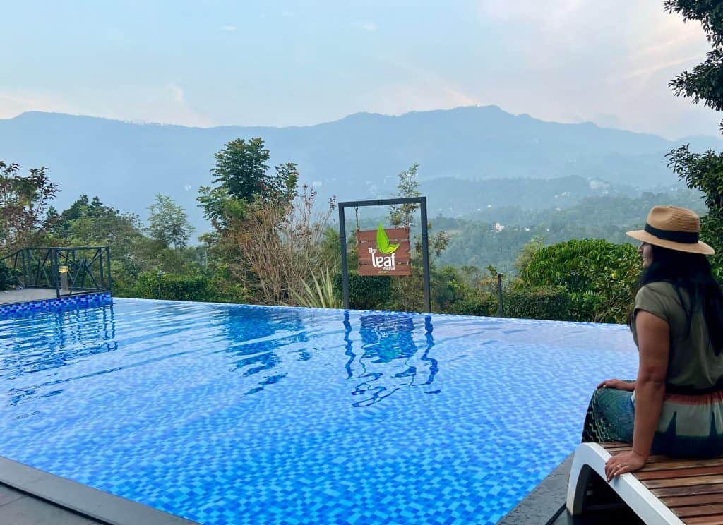 Eco-friendly hotels in Kerala: Infinity poo views, with Bejal sitting on the side at The Green leaf, Munnar