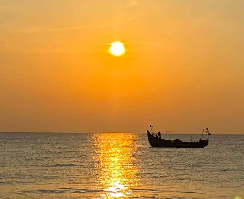 Eco-friendly Hotels in Kerala: fishing boat and Marari Beach sunset