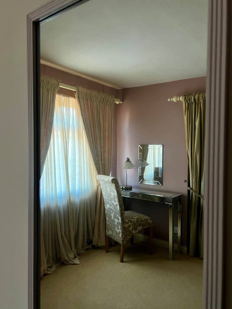 Desk/dressing room area in room through mirror