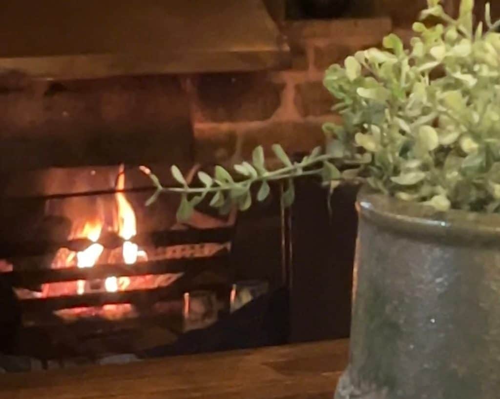 Indian food & Rooms: The Marquess of Exeter: fire in bar with a floral vase
