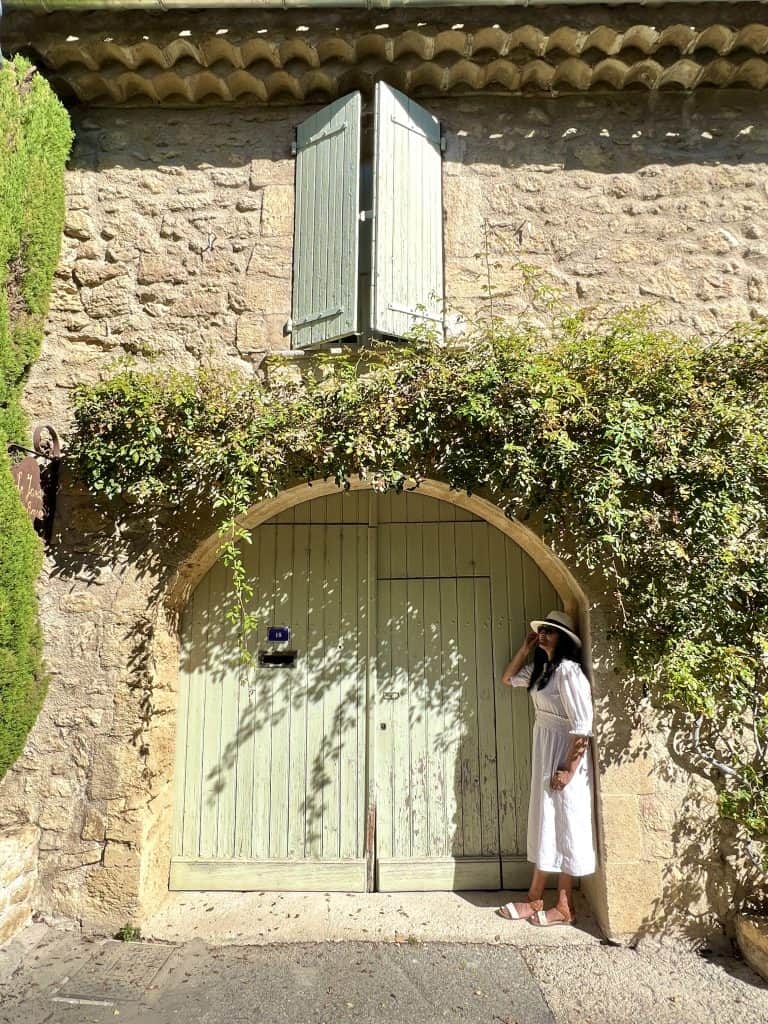 Bejal standing in front of pastel green door in Ansouis, Provence