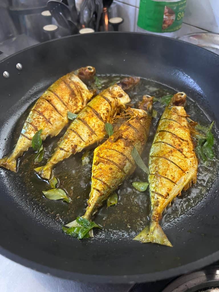 Masala fish being fried in a pan on Fort Kochi cookery class at Sheeba's house 