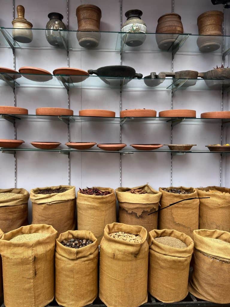 Sacks of spices and shelves full pf cooking clap pots and vases in the spice market in Jew Town.