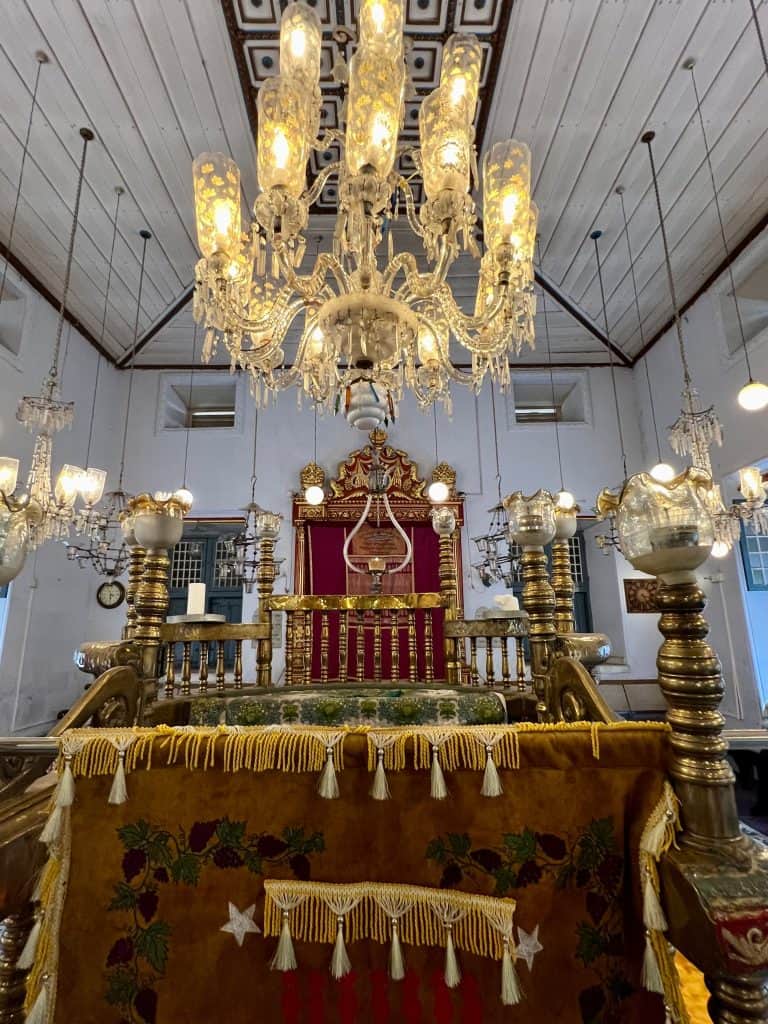 The interiors of the of the Paradesi Synagoge in Mattancherry with a huge chandelier in the middle of the prayer space.