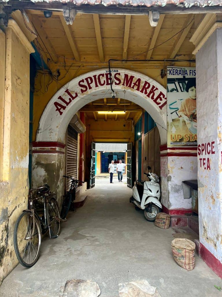 48 hours in Fort Kochi. The archwasy of a local hidden gem of a spice market with guides peering through.