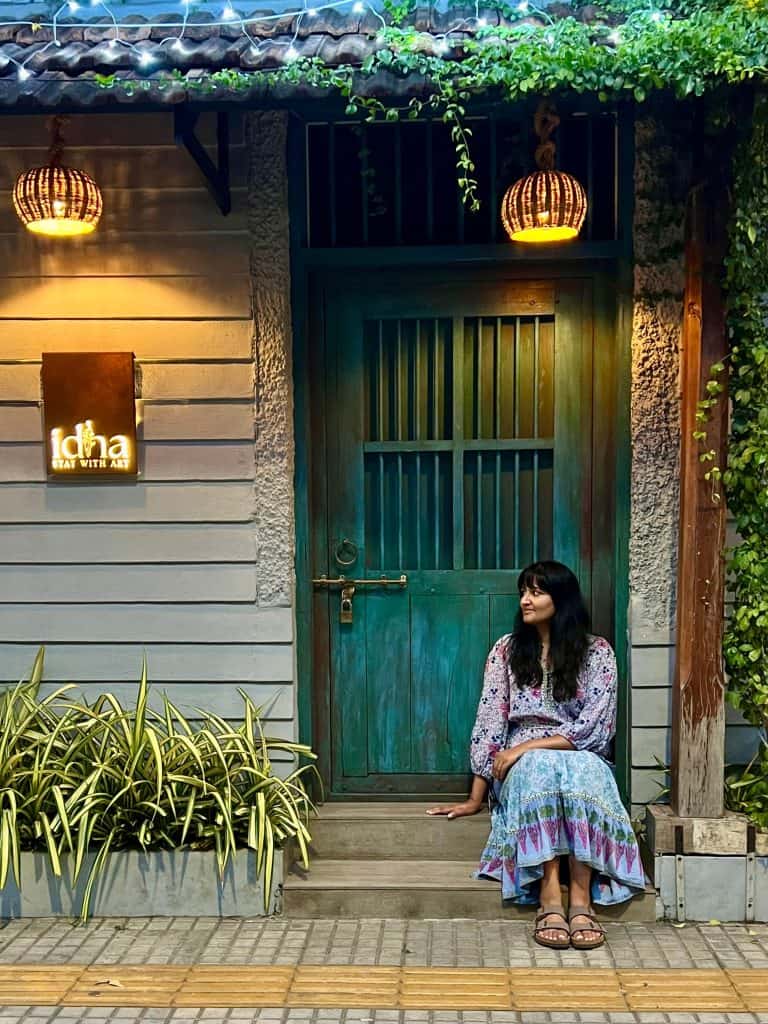 Bejal sitting in front of door of cafe on Princess Street in Fort Kochi