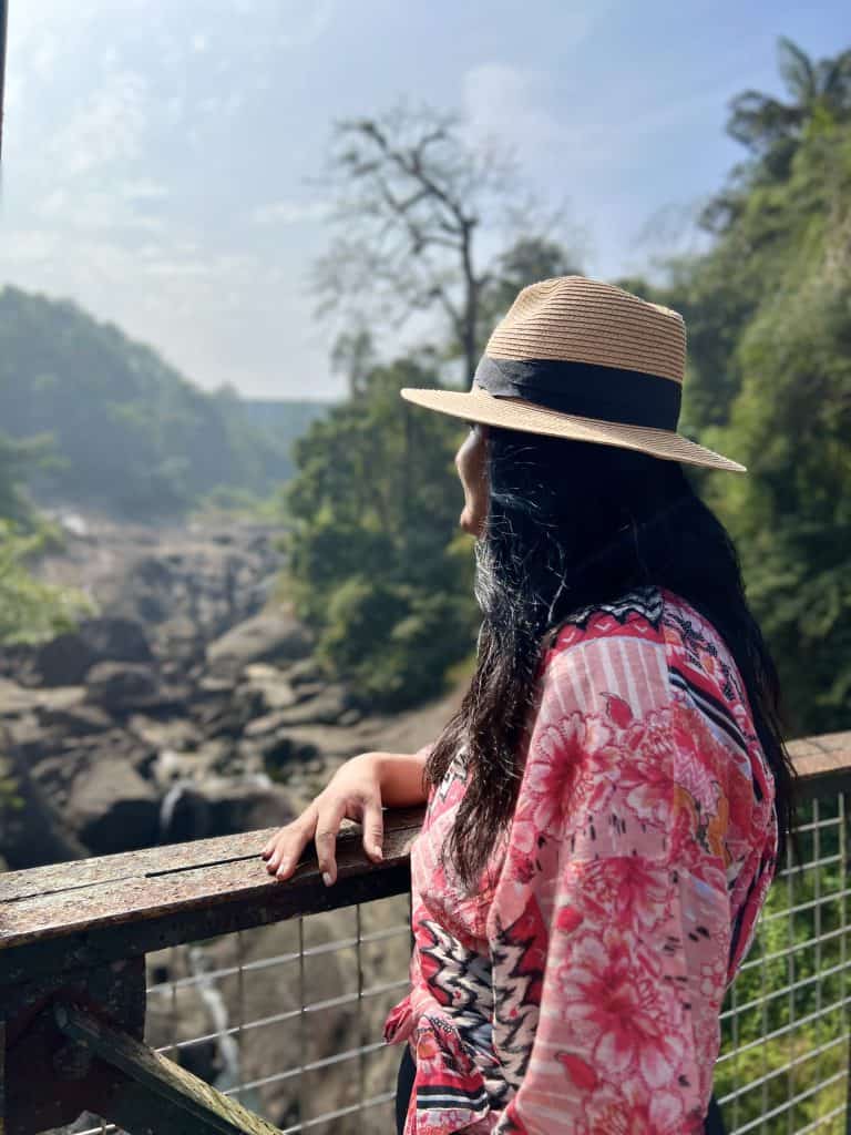 Things to do in Munnar, Bejal standing looking out over Mattupetty bridge. There are boulders in the background.