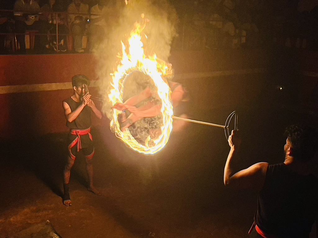 The Kalaris making a fire wheel with a man jumping through the centre at Mudra Cultural Kalaripayattu show in Thekkady, Kerala
