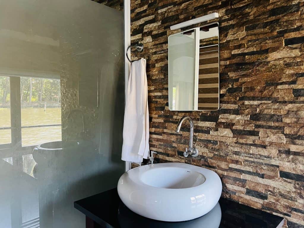 Beautiful Kerala backwaters: Bathroom basin in Pickadly houseboat with brown tiles on the wall.