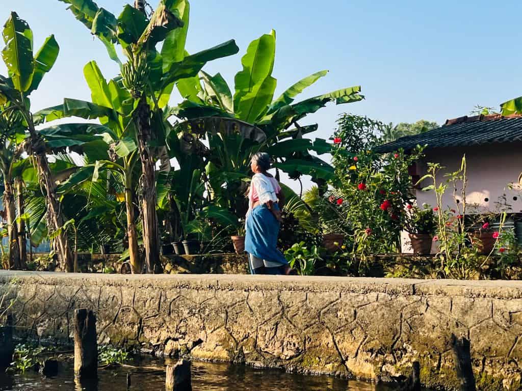 A lady standing on the canal bank at a village along the backwaters.