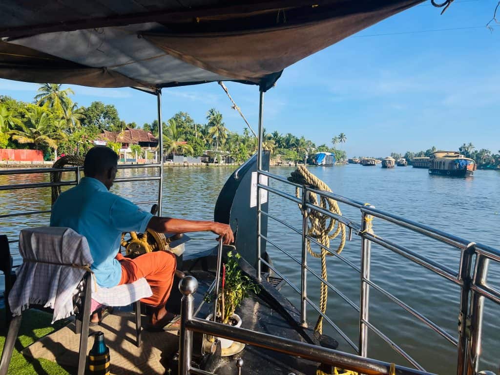 Captain steering the houseboat back to Alleppey at the end of the cruise
