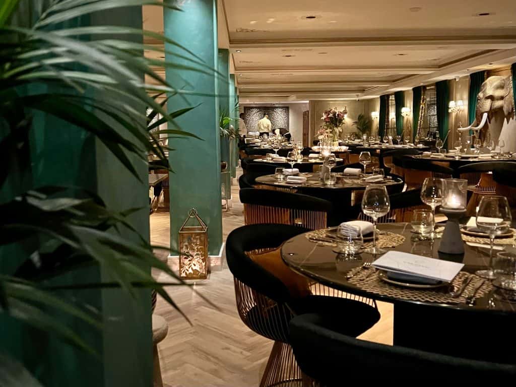 The main dining room with a teal wall and plant to the left hand side at Varansi, Leicester