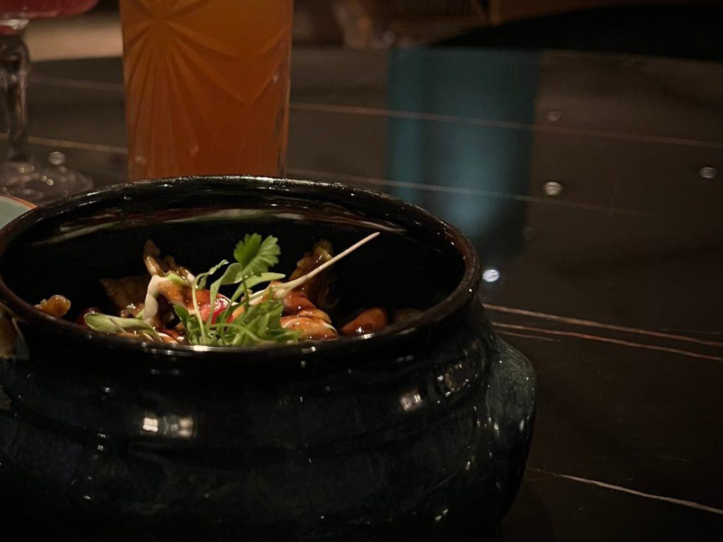 The pari chat in a black bowl with atmospdheric lighting.