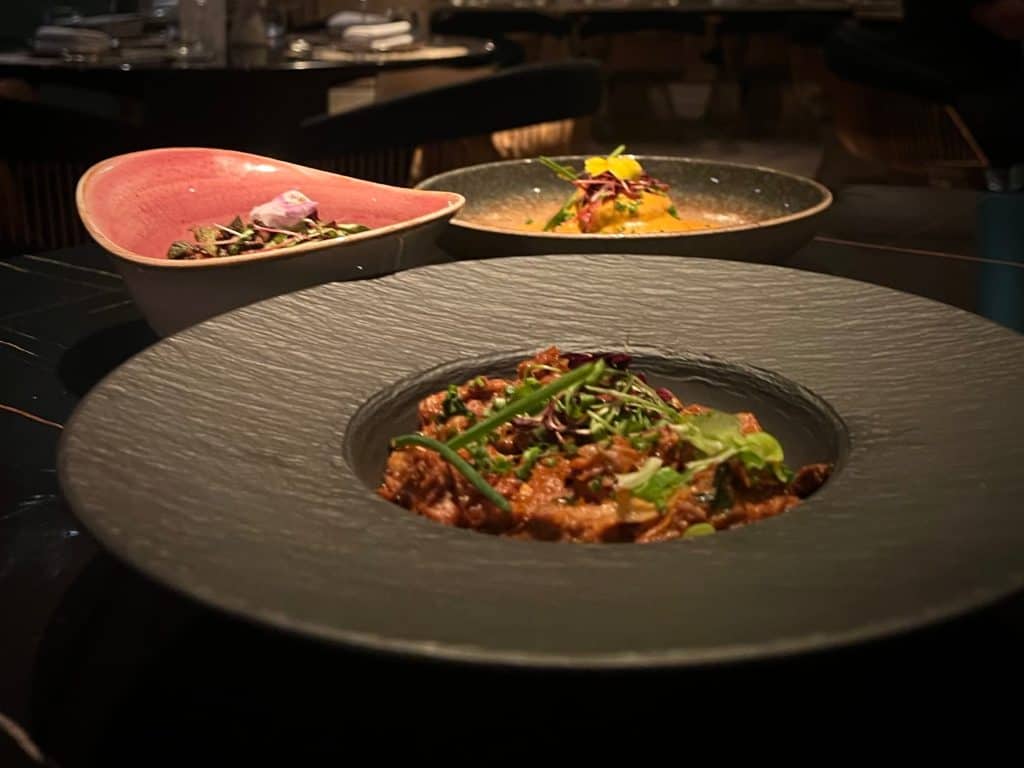 Close-up of shredded lamb, with other dishes in the background