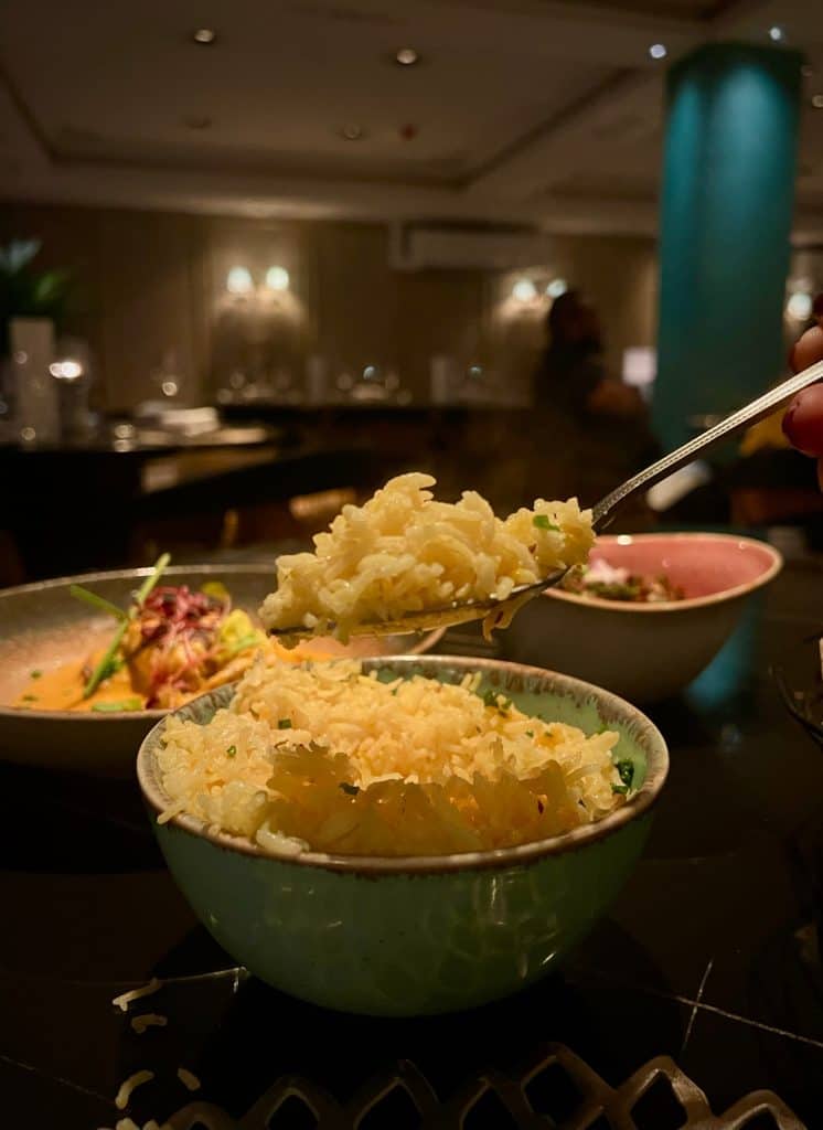 Indian Fine Dining At Varanasi: Spoonfull of pilau rice with other dishes in the background at Varanasi, Leicester