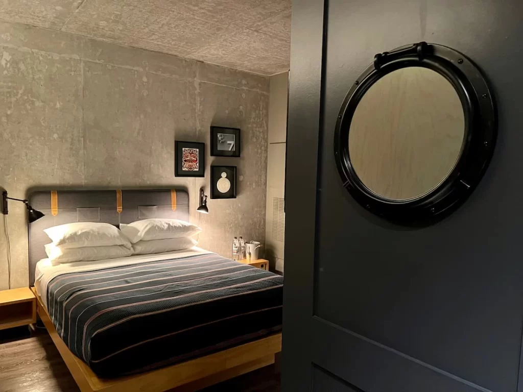 Moxy San Diego bed in the background with large round miroor