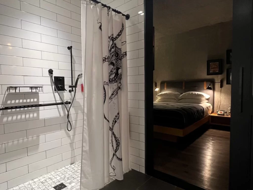 Moxy San Diego black and white bathroom with bed showing the background