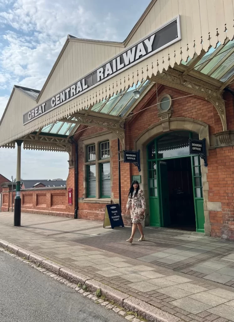 Bejal in a pink dress walking out of the Great Central Railway Station, Loughborough