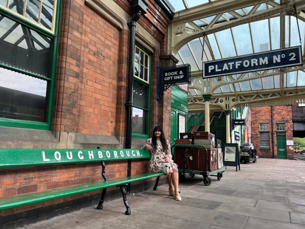 Bejal sat on bench with Loughborough signage at Loughborough Central Station