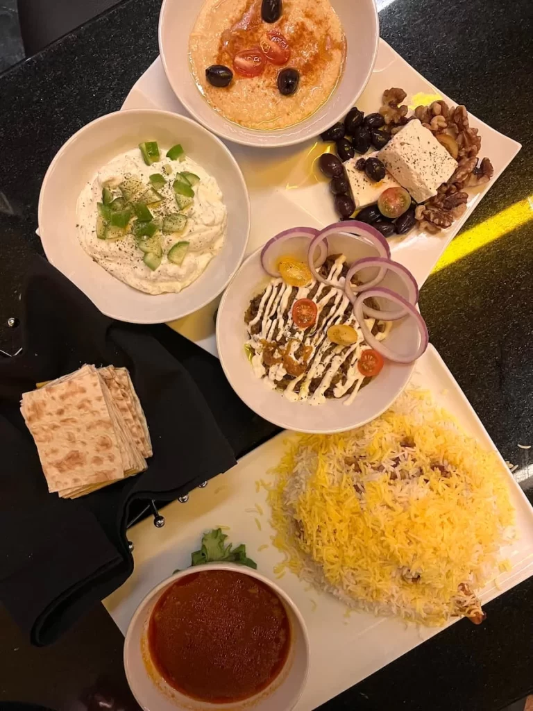 A flatlay of 3 Meze plates and a stew with rice at Bandar, San Diego